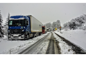 Photo de camion sur une route enneigée 